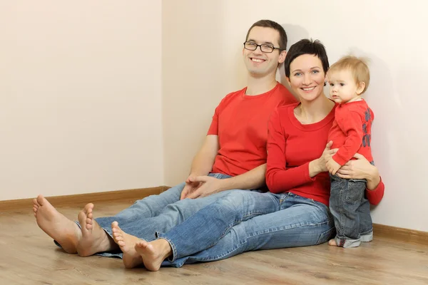 Família feliz em jeans e camisas vermelhas — Fotografia de Stock