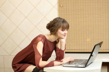 evde bir bilgisayar üzerinde çalışan sıradan bir kız