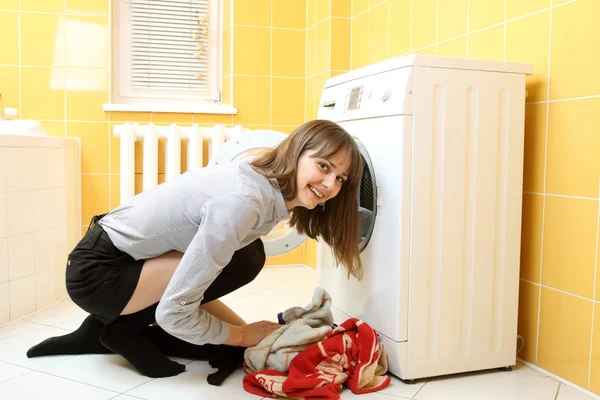 Ordinary simple beautiful girl near a washing machine — Stock Photo, Image