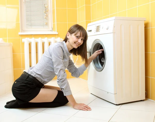 Ordinary simple beautiful girl near a washing machine — Stock Photo, Image