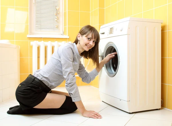 Ordinary simple beautiful girl near a washing machine — Stock Photo, Image