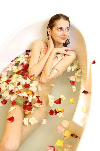 Gül yaprakları ile bir banyoda kadını — Stok fotoğraf