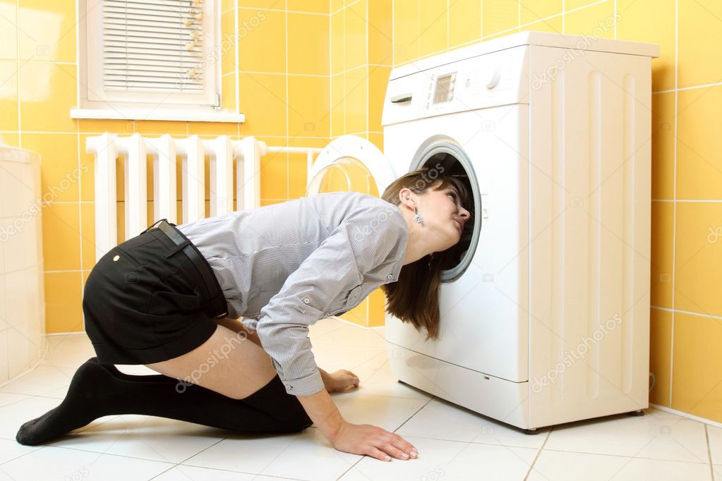 Ordinary simple beautiful girl put her head into a washing machine