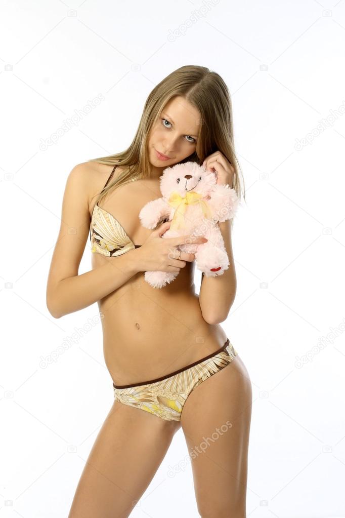 Portrait of a young seductive girl in a bright bikini with a toy