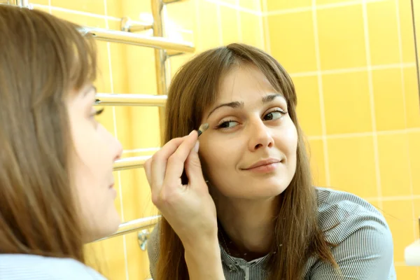 Trevlig tjej gör makeup i badrummet — Stockfoto