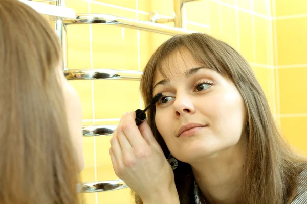 Buena chica haciendo maquillaje en el baño —  Fotos de Stock