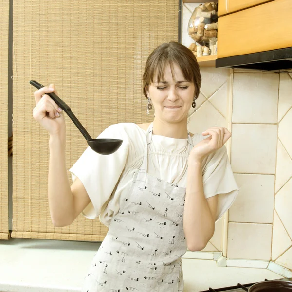 Trevlig normal tjej i en ljus klänning försöker skopa mat — Stockfoto