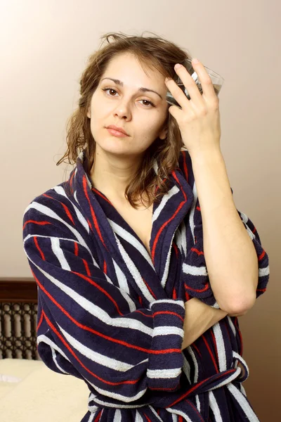 Eine Frau im Bademantel leidet unter Kopfschmerzen — Stockfoto