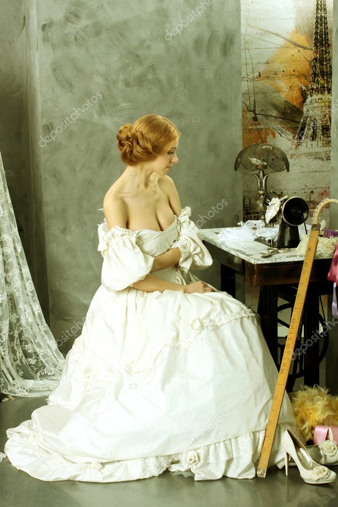 Woman in vintage dress sitting near retro sewing machine