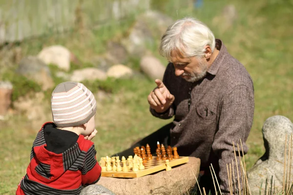 Grand-père et petit-fils jouant aux échecs — Photo