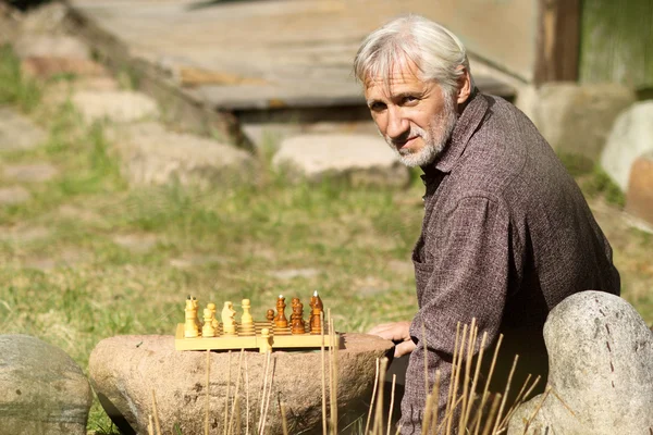 Uomo dai capelli grigi che gioca a scacchi — Foto Stock