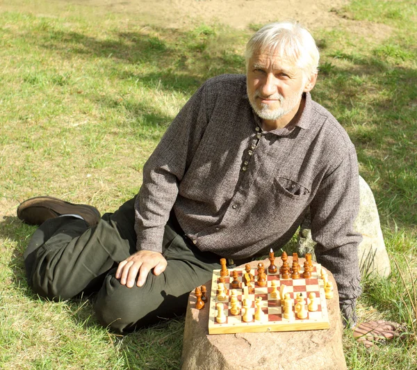 Gray-haired man playing chess — Stock Photo, Image