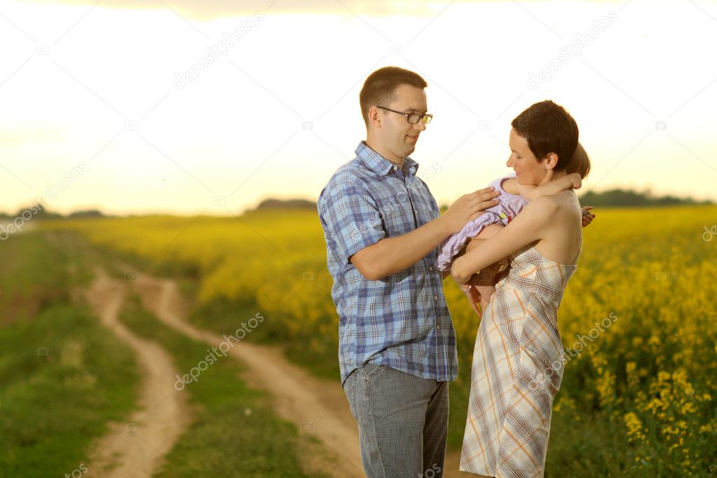 Mother and father with their little daughter in a field