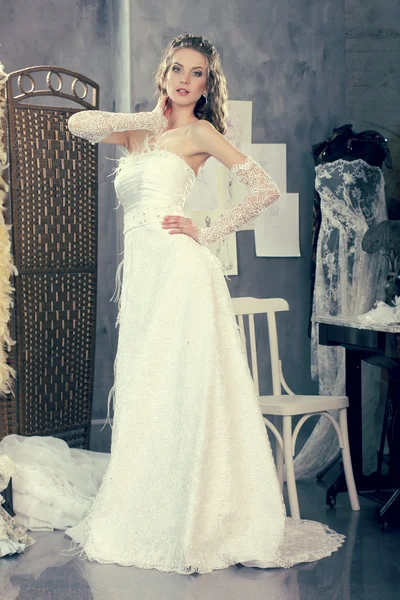 Dziewczyna w sukni ślubnej sprawia, że montaż w studio projektowania odzieży — Zdjęcie stockowe