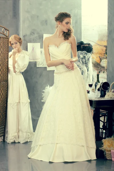 Dziewczyny w sukni ślubnej zrobić montaż w studio projektowania odzieży — Zdjęcie stockowe