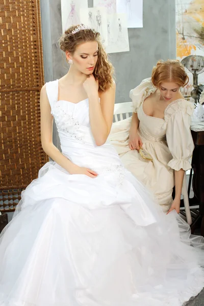 Las niñas en un vestido de novia hacer ajuste en el estudio de diseño de ropa —  Fotos de Stock