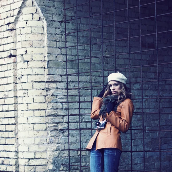 Девушка со старым фотоаппаратом прогуливается по старинным улицам — стоковое фото