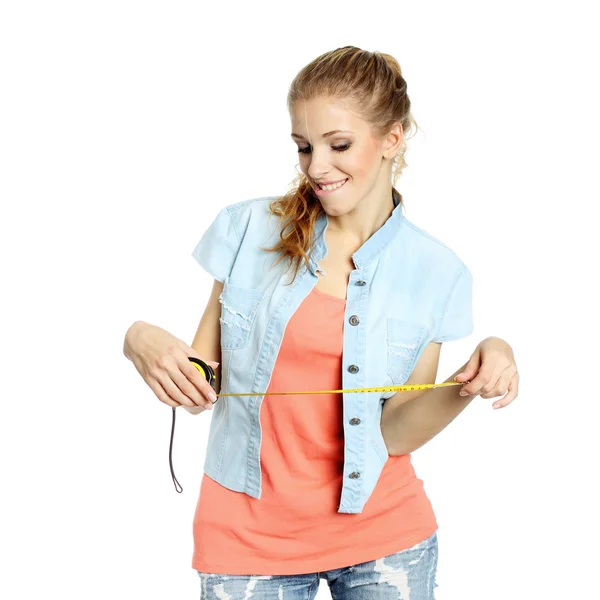 Pleased girl looks down at tape measure — Stock Photo, Image