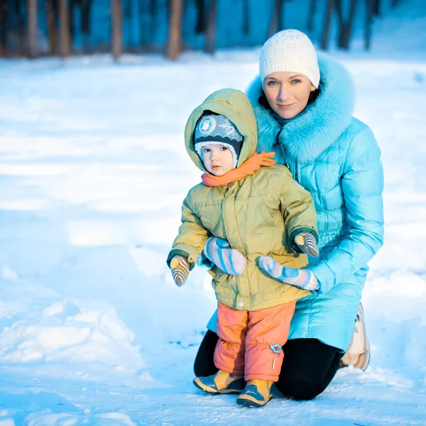 Matki z jej małą córeczkę w ramionach w zimie — Zdjęcie stockowe