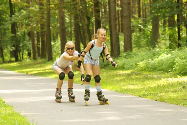 Mother and daughter learn to roller skate — Stock Photo, Image