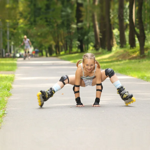 Petite fille tombe sur les patins à roulettes — Photo