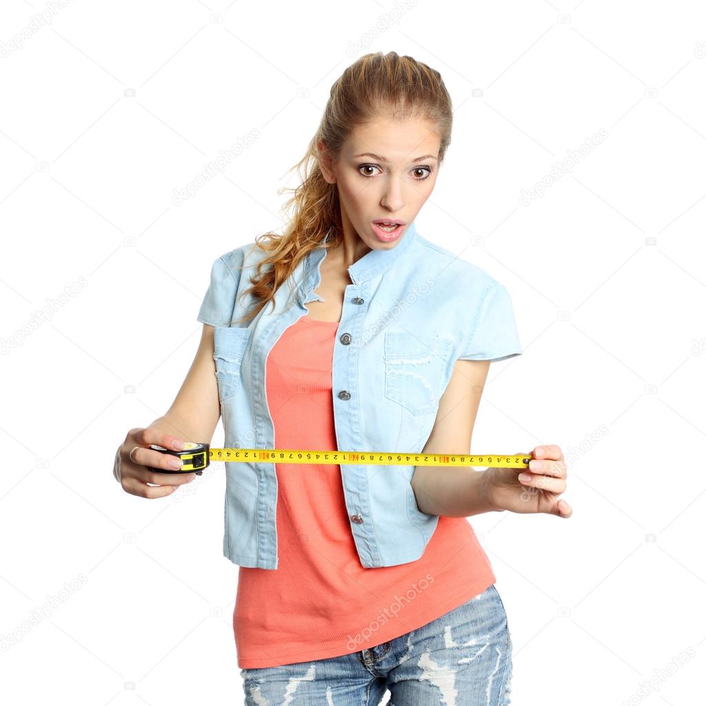 Concerned girl looks down at tape measure