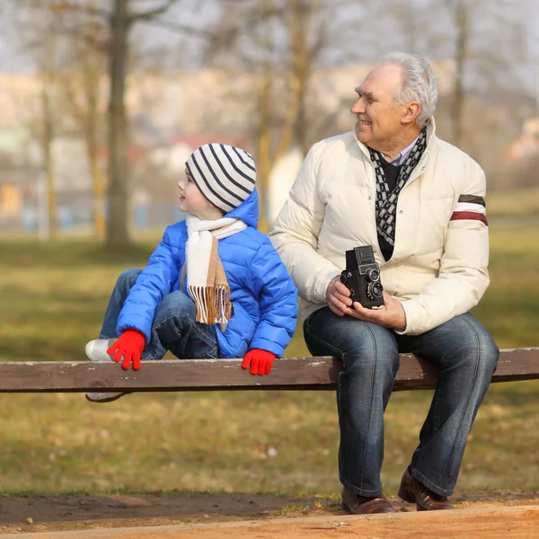 Grandfather shows grandson vintage camera — Stock Photo, Image