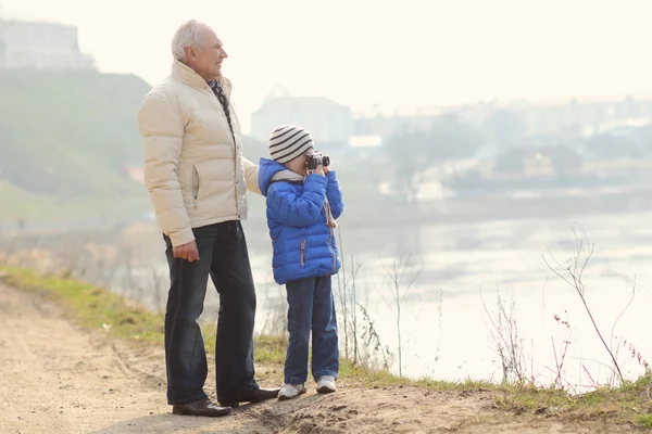 Grandfather and grandson make photo on a vintage camera — Stock Photo, Image