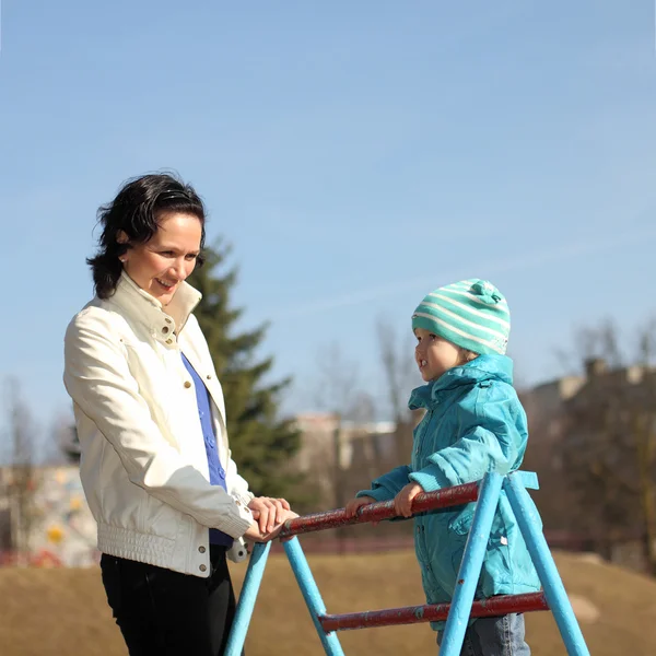 Belle jeune mère faisant du fitness avec sa petite fille à l'aire de jeux — Photo