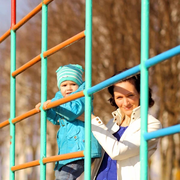 Bela jovem mãe fazendo fitness com sua filhinha no playground — Fotografia de Stock