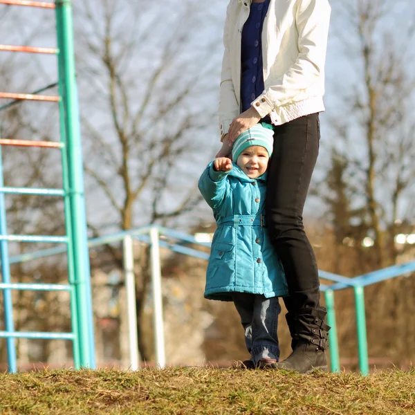 Petit enfant tient sur les pieds maman — Photo