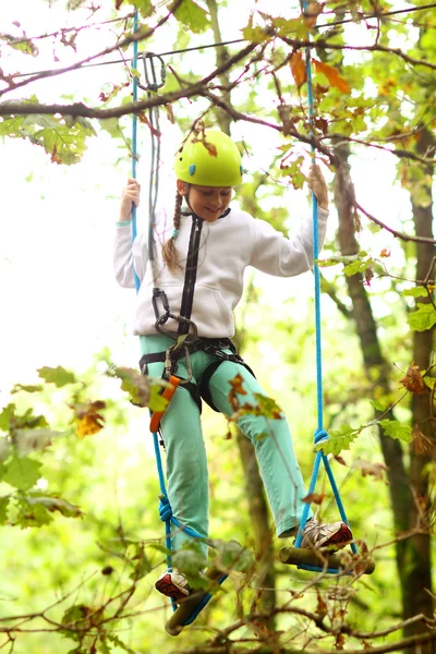 Klimmer meisje die zich bezighouden met de opleiding tussen bomen — Stockfoto