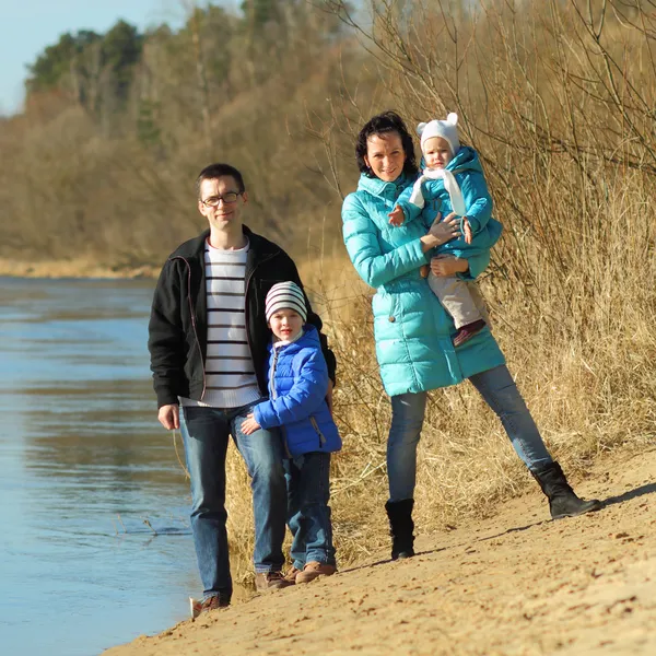 Hermosa familia joven cerca del río — Foto de Stock