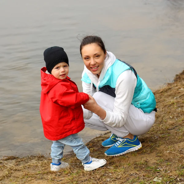 Belle jeune famille s'amusant près de la rivière — Photo