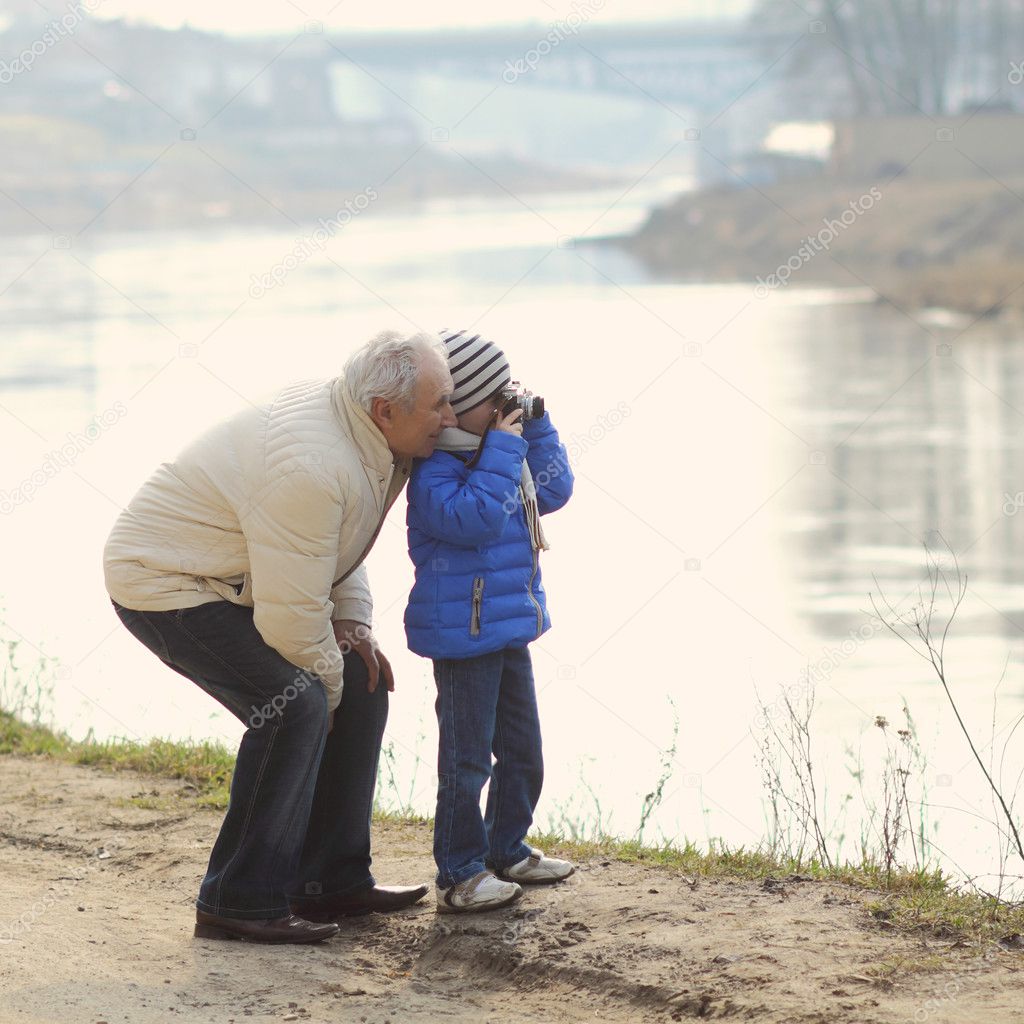 Grandfather and grandson make photo on a vintage camera