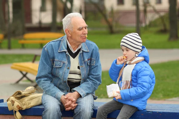 Grandfather and grandson eating — Stock Photo, Image