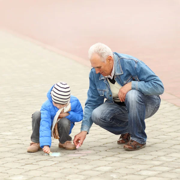 Grand-père et petit-fils dessinent à la craie — Photo