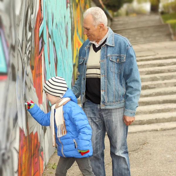 Grandfather and grandson paint graffiti — Stock Photo, Image