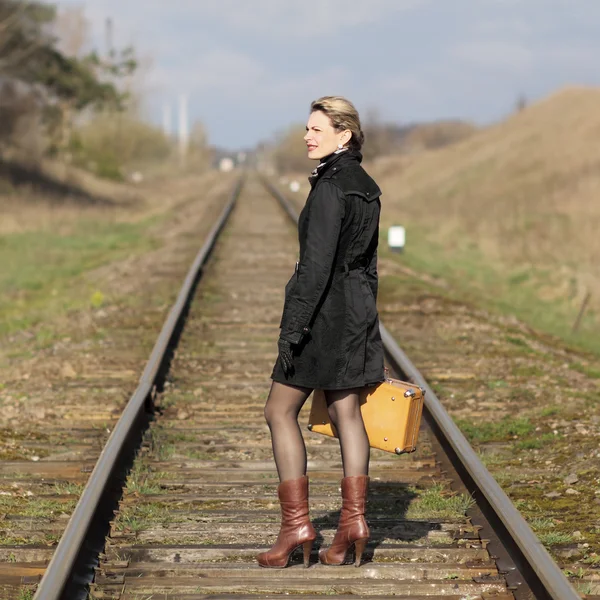 Vrouw in een zwarte jas en handschoenen — Stockfoto