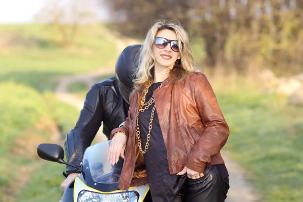 Motorkářka s sluneční brýle sedí na motocyklu — Stock fotografie