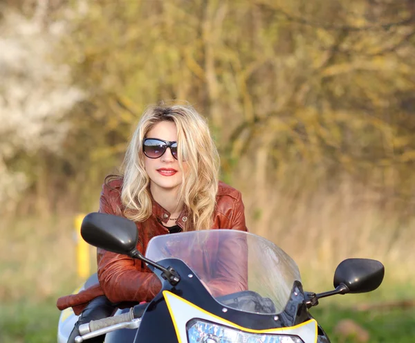 Motorradfahrerin mit Sonnenbrille sitzt auf Motorrad — Stockfoto