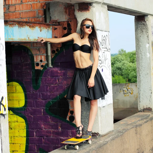 Girl in top and skirt with skateboard — Stock Photo, Image