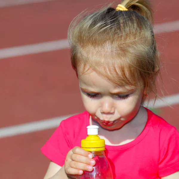 Lilla flickan dricka vatten från flaska — Stockfoto