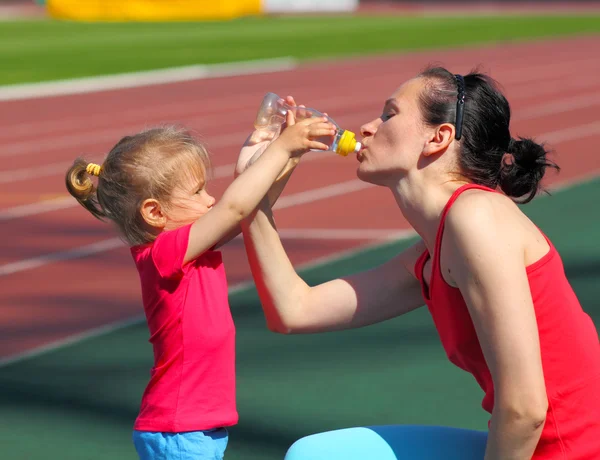 Kız anne su içmek için verir — Stok fotoğraf