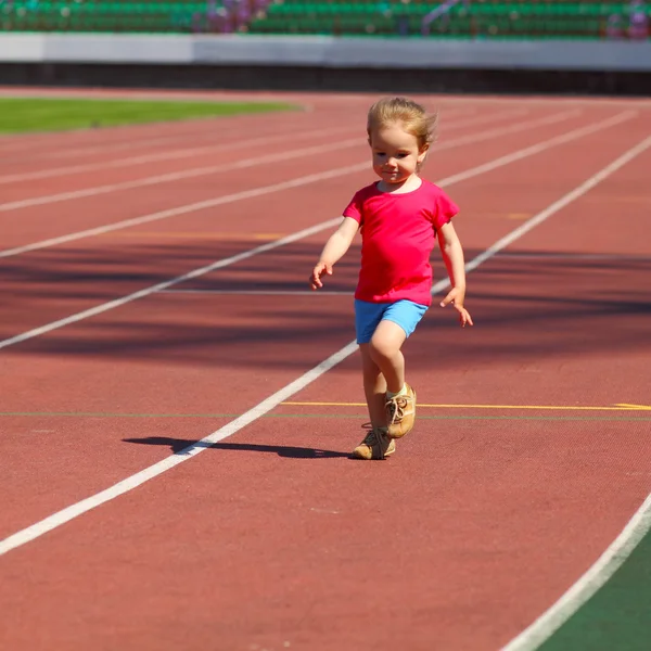 Little girl running at the stadium — Stock Photo, Image