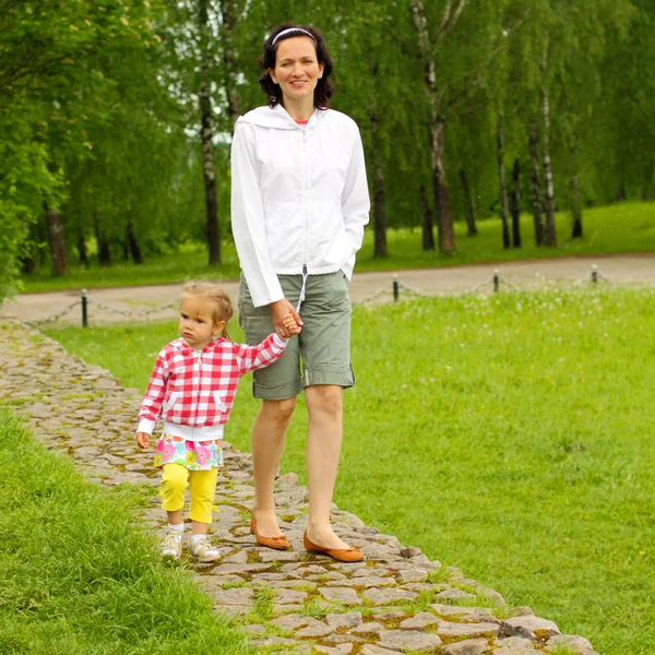 Mãe e filha andando no parque — Fotografia de Stock