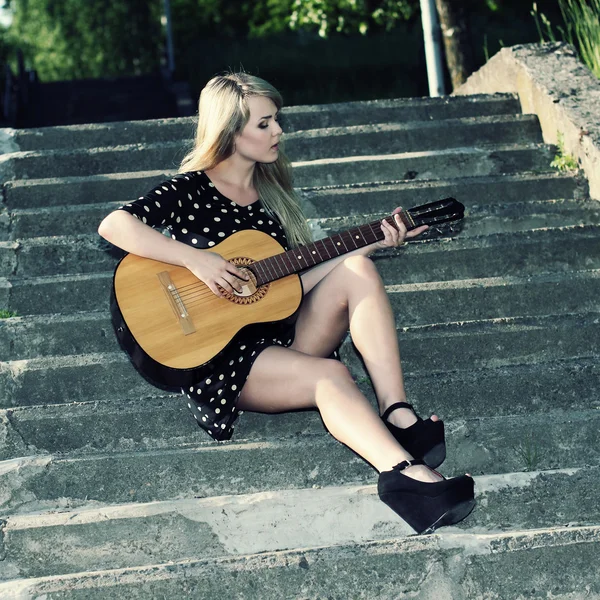 Girl sitting on stairs with guitar — Stock Photo, Image