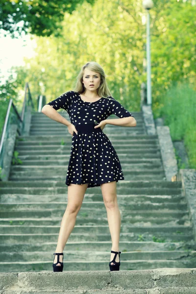 Модная девушка, стоящая на лестнице — стоковое фото