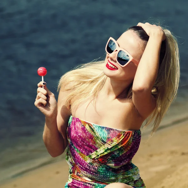 Mujer con piruleta en la playa de arena —  Fotos de Stock