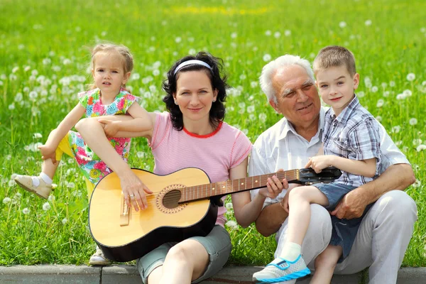 Mother playing guitar for her children — Stock Photo, Image